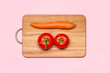 Bir havuç yakınındaki iki taze domates