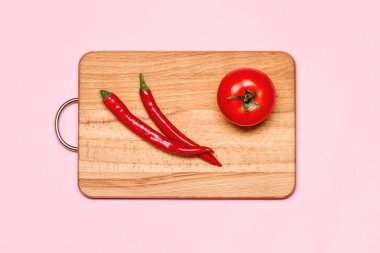 İki kırmızı biber biber taze domates yakınındaki