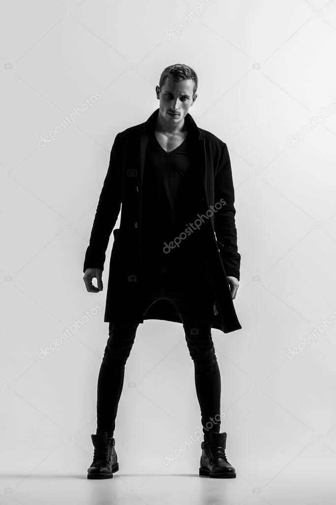 Handsome Fashion Man In Black Coat Posing On White Background. Model Test