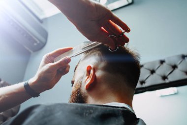 BARBERshop teması. BARBER, Bıyıklı müşterisinin saçlarını kesmeye çalışıyor. Bir makas ve kostüm kullanıyor.