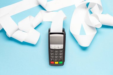 Mavi arka planda uzun kasiyer bandı olan pos terminal. alışveriş teması