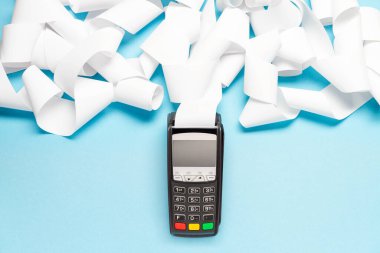 Mavi arka planda uzun kasiyer bandı olan pos terminal. alışveriş teması