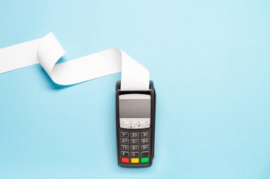 Mavi arka planda uzun kasiyer bandı olan pos terminal. alışveriş teması