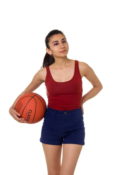 Bruneta žena držící basketbal v ruce izolované na bílém pozadí — Stock fotografie