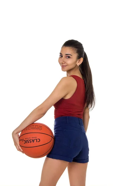 Mulher morena bonita segurando Basquete na mão isolado em um fundo branco — Fotografia de Stock