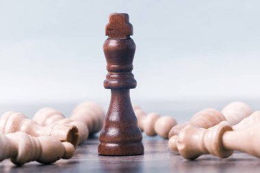 Masanın üzerinde bir siyah satranç kralı figürü var. Piyonların yattığı yerde. iş başarısı konsepti.