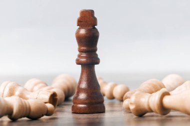 Masanın üzerinde bir siyah satranç kralı figürü var. Piyonların yattığı yerde. iş başarısı konsepti.