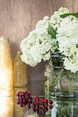 Gözlüklü gül kırmızısı şarap. Arka planda çiçekler olan bir şişe gül şarabı. Prosecco.