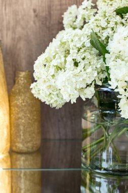 Gözlüklü gül kırmızısı şarap. Arka planda çiçekler olan bir şişe gül şarabı. Prosecco.