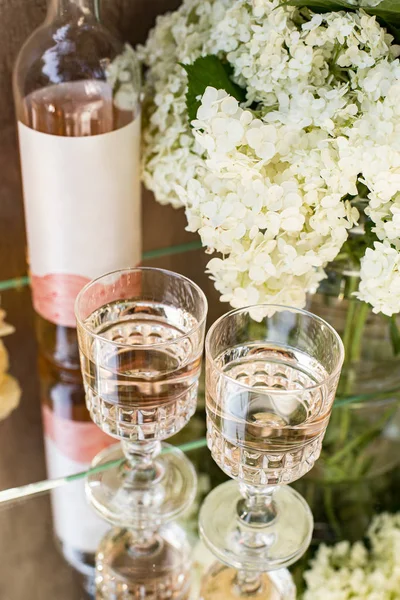 Rose blush wine in glasses. Bottle of rose wine with flowers on background. Prosecco.