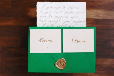 Wedding details flat lay. Wooden background. Wedding invitation. Wedding bouquet. Mock up. Envelope. Copy space.