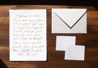 Wedding details flat lay on wooden background. Wedding invitation. Wedding bouquet. Mock up. Envelope. Copy space.