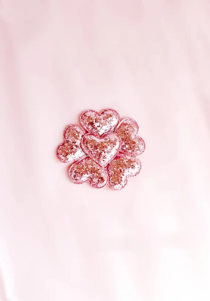 Pembe, pırıl pırıl kalpleri olan bir arka plan. Pembe kağıt üst görünüm, düz döşeme, minimum stil. Kartı çalıştır..