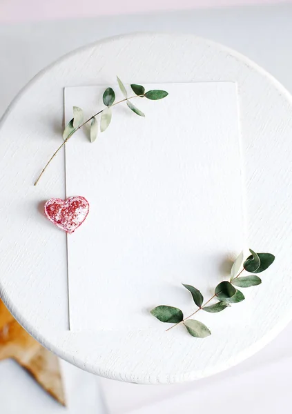 Background with copy space blank on white table with glitter heart, eucalyptus branch, flowers and leafs. White paper top view, flat lay, minimal style. Moke up card. — 스톡 사진