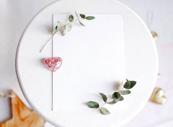 Background with copy space blank on white table with glitter heart, eucalyptus branch, flowers and leafs. White paper top view, flat lay, minimal style. Moke up card. — 스톡 사진