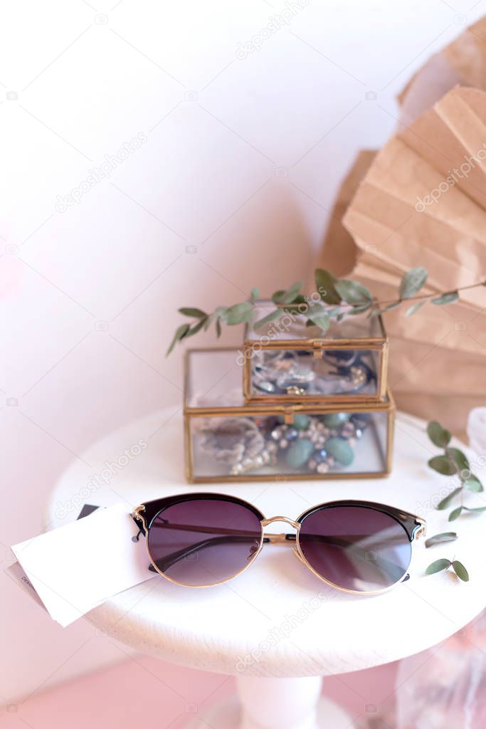 Beautiful fashion accessory for woman. Sunglasses on white and brown background. Copy space moke up accessories.