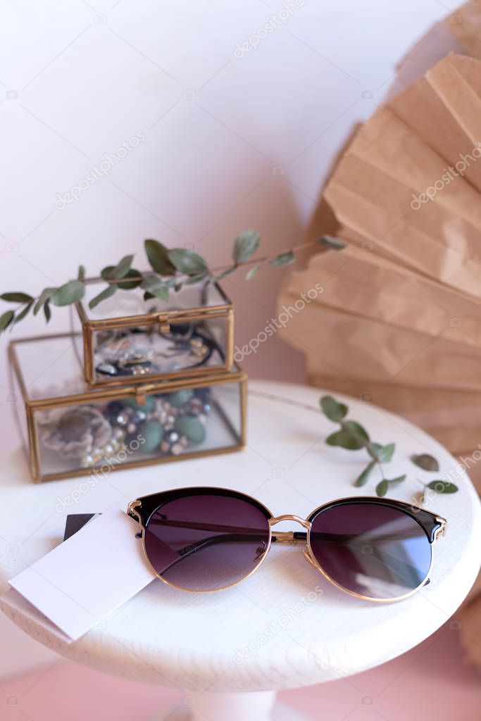 Beautiful fashion accessory for woman. Sunglasses on white and brown background. Copy space moke up accessories.