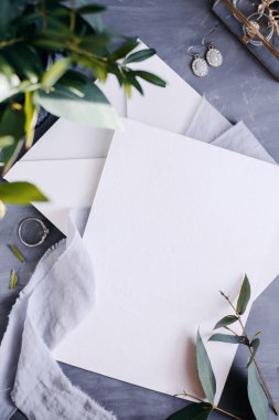 Boş kağıt kopyalama alanı. Çiçeklerle çerçevelenmiş. İpek kurdele. Gri arka plan. Basit bir buket. Tebrik kartı.