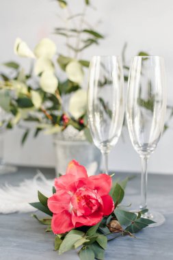 Composition with glass for champagne. Flowers and hearts on grey concrete background.