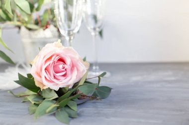 Composition with glass for champagne. Flowers and hearts on grey concrete background.