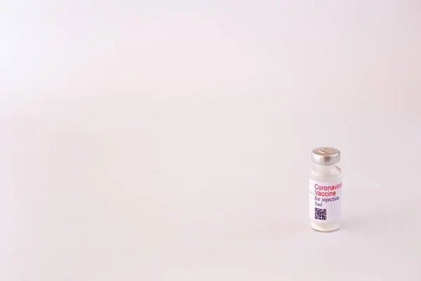 Coronavirus aşısı. Ampulde tıbbi hazırlık. Hastalığın tedavisi, covid-19. Aşı beyaz arka planda ve şırınganın arka planında, lastik eldiven ve gözlüklerde.