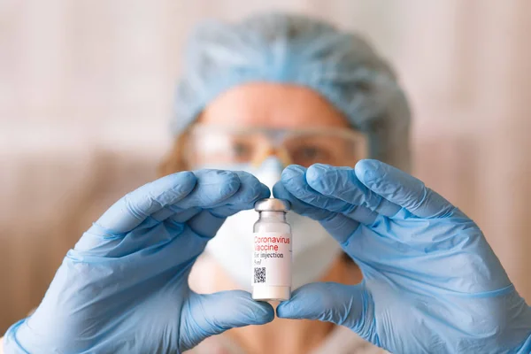 Coronavirus aşısı. Aşısı olan bir doktor. Hemşire koronavirüs aşısı tutuyor. Covid-19 'a karşı Coronavirus aşısı ampulü tutan eller..