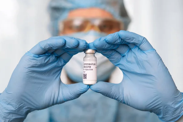 Coronavirus aşısı. Aşısı olan bir doktor. Covid-19 'a karşı Coronavirus aşısı ampulü tutan eller..