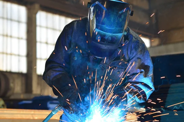 Fabrikada çalışan kaynakçılar metal üretiyorlar.