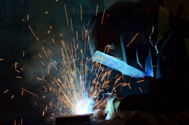 Fabrikada çalışan kaynakçılar metal üretiyorlar.