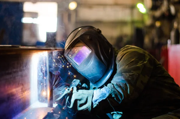 Fabrikada çalışan kaynakçılar metal üretiyorlar.