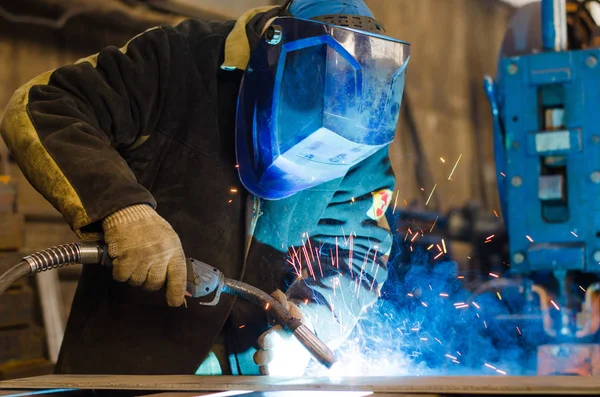 Fabrikada çalışan kaynakçılar metal üretiyorlar.