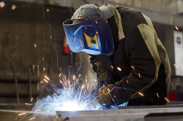 Fabrikada çalışan kaynakçılar metal üretiyorlar.