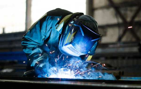 Fabrikada çalışan kaynakçılar metal üretiyorlar.