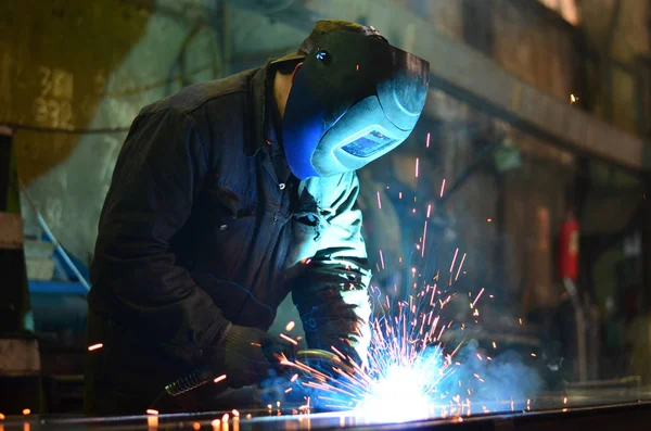 Fabrikada çalışan kaynakçılar metal üretiyorlar.