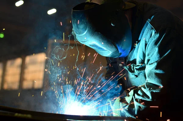 Fabrikada çalışan kaynakçılar metal üretiyorlar.