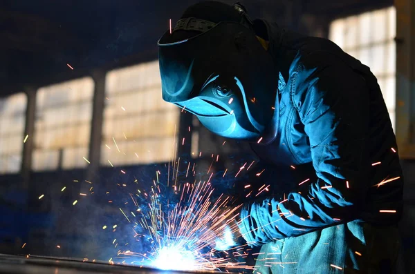 Fabrikada çalışan kaynakçılar metal üretiyorlar.