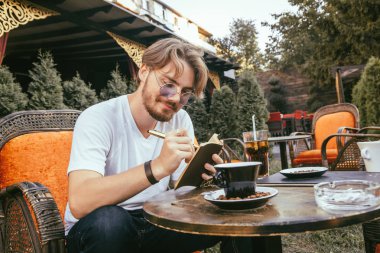 Genç adamın sakalı boş nota yazıyor.