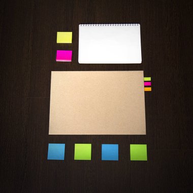 Koyu ahşap arka plan iş marka şablonunda mockup. İleti örneği ile not etmek, geri dönüşümlü klasör kümesi renkli