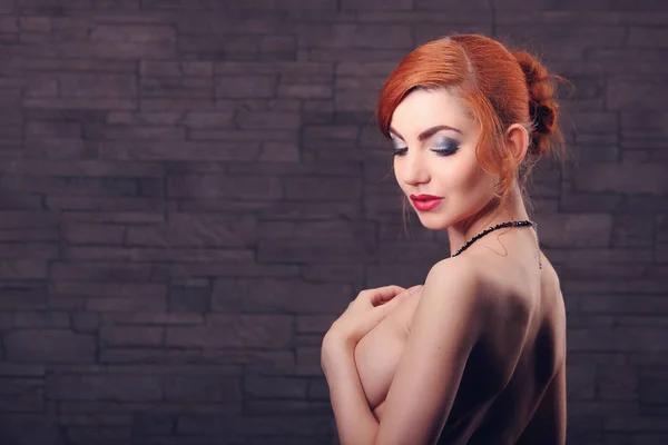 Retrato de una hermosa mujer desnuda cubriendo su pecho contra el beige — Foto de Stock
