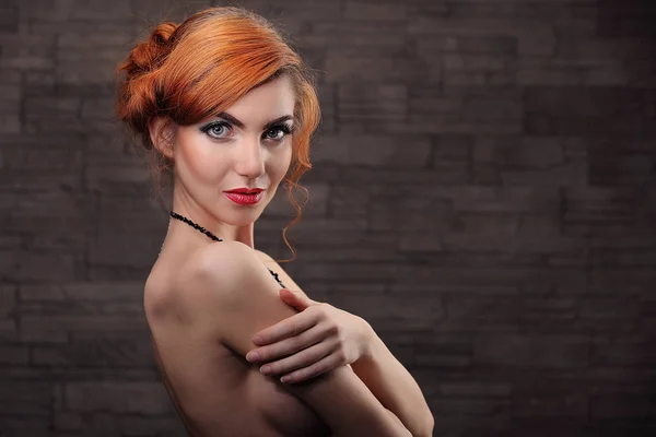 Porträtt av härlig naken kvinna som täcker hennes bröst mot beige — Stockfoto