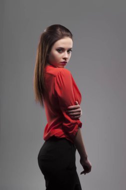 Gri arka plan üzerinde poz çok seksi moda şehvetli esmer kadın kırmızı gömlek giymiş. Yarı aç