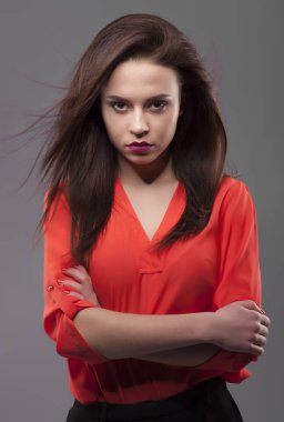 Kırmızı gömlek, gri arka plan kız. Saç hareket ile esmer kadın neşeli genç moda