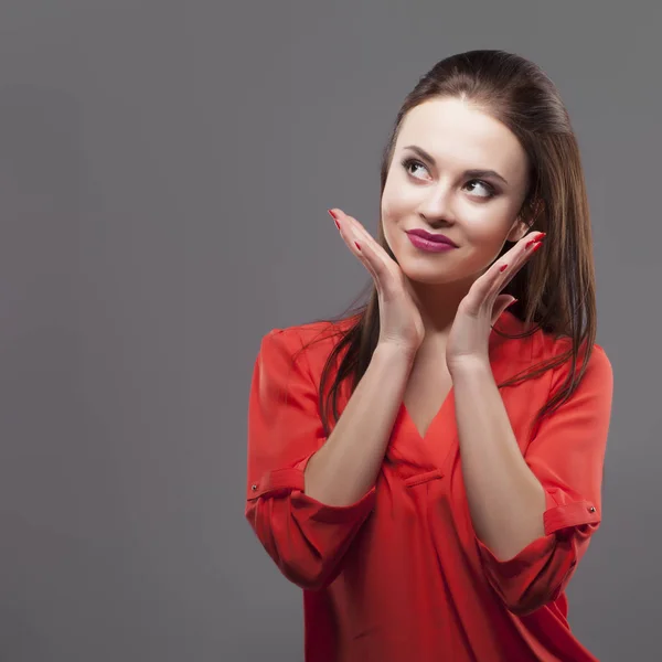 Ragazza in camicia rossa, sfondo grigio. Gioioso giovane donna bruna di moda . — Foto Stock