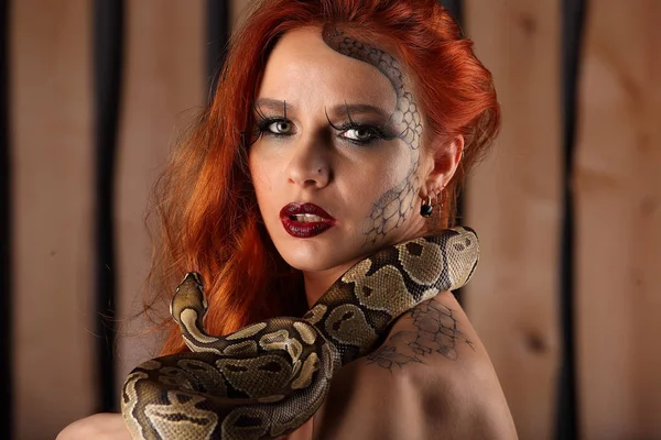 Nacktporträt der schönen jungen Frau mit orangefarbener Python — Stockfoto
