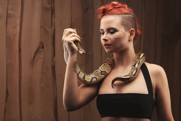 Porträtt av härlig ung kvinna med orange python — Stockfoto