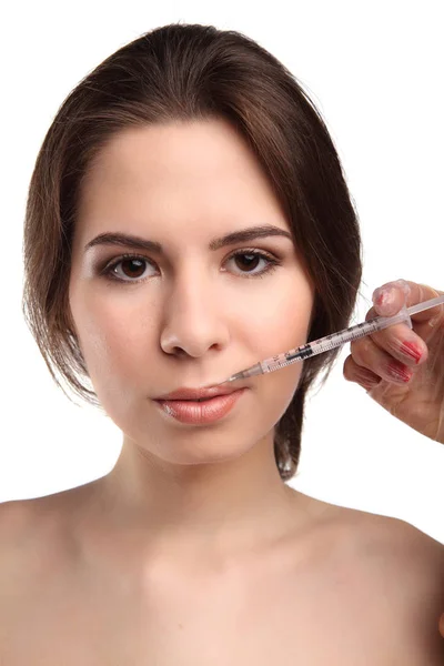 Jeune femme séduisante obtient injection cosmétique, isolé. Médecins mains faisant une injection dans le visage. Traitement de beauté . — Photo
