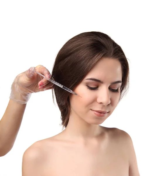 Aantrekkelijke jonge vrouw krijgt cosmetische injectie met gesloten ogen, geïsoleerd op witte achtergrond. Artsen handen maken een injectie in gezicht. — Stockfoto