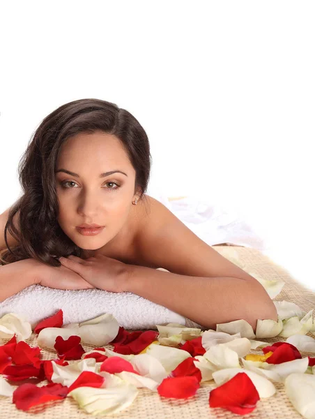 Relaxed woman at health day spa, laying in white towel on bamboo table decorated with rose petals — Stock Photo, Image