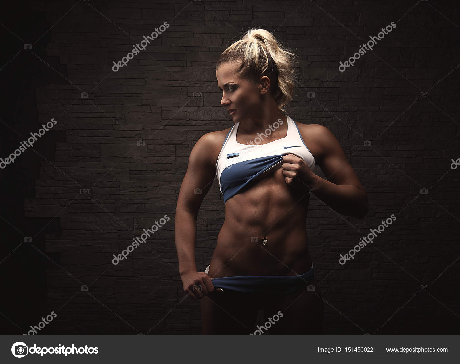 Strong woman Fitness Model showing six pack abs. Young sexy bodybuilder.  girl with muscle cubes on press. Sport concept image. Stock Photo by  ©fenixlive 151450022