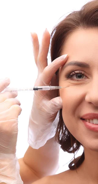 Cosmetische injectie in het vrouwelijke gezicht op witte achtergrond. Artsen handen maken een injectie in gezicht. Beauty behandeling concept, de helft van het gezicht afbeelding closeup — Stockfoto